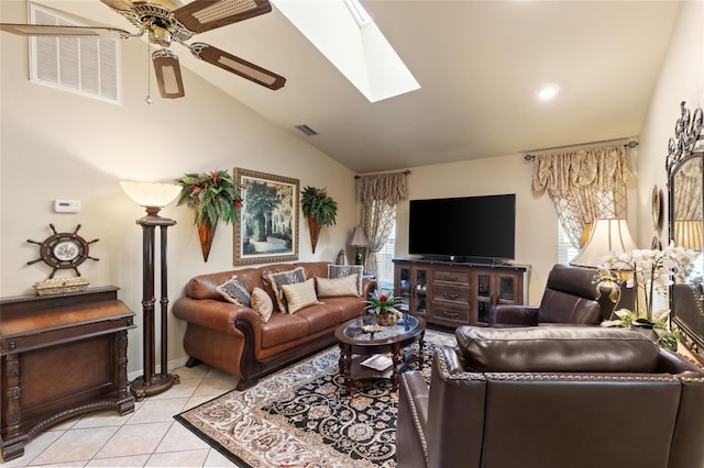 living area featuring vaulted ceiling with skylight, visible vents, a ceiling fan, and light tile patterned flooring