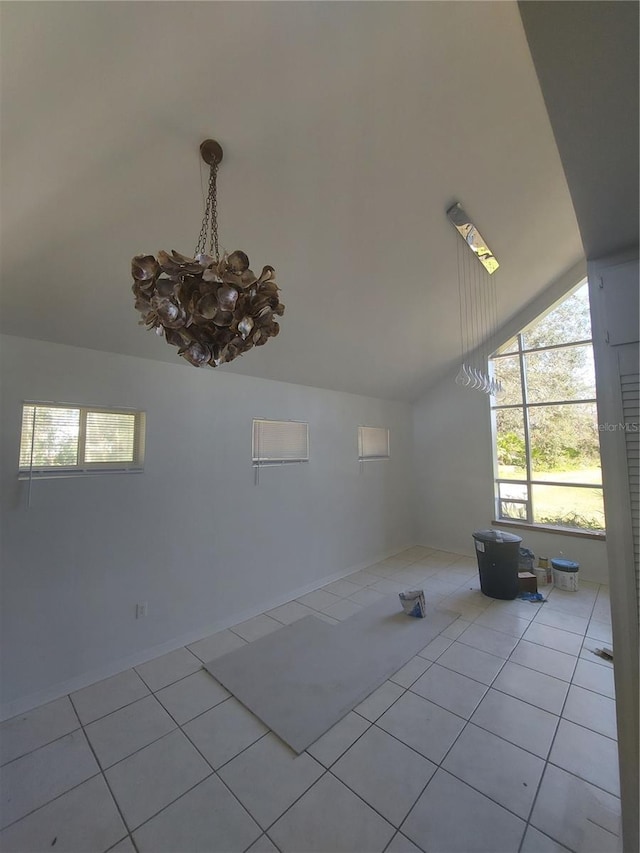 tiled spare room featuring vaulted ceiling and an inviting chandelier