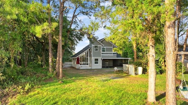 rear view of house featuring a yard