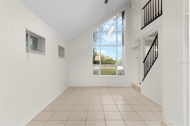interior space with high vaulted ceiling, visible vents, stairway, light tile patterned floors, and baseboards