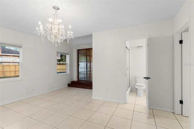 unfurnished room featuring baseboards, an inviting chandelier, and light tile patterned floors