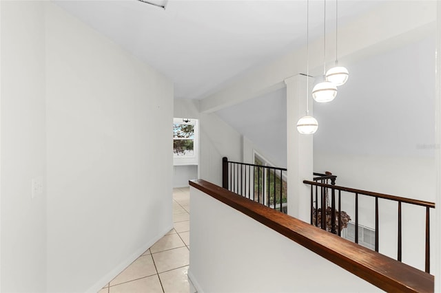 hall with light tile patterned floors, baseboards, an upstairs landing, and lofted ceiling with beams
