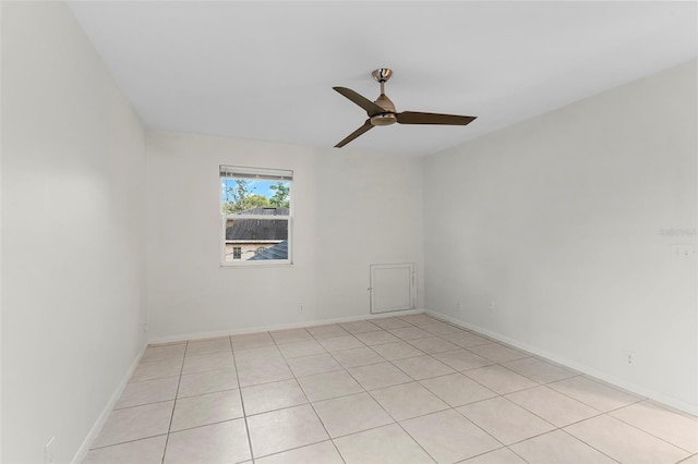 spare room with ceiling fan, baseboards, and light tile patterned floors