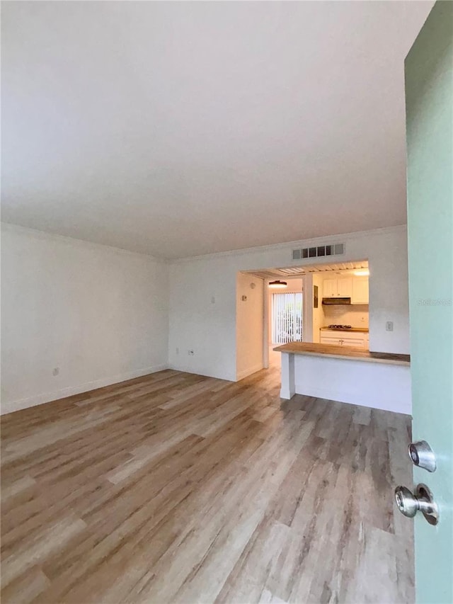 unfurnished living room with light wood-type flooring and visible vents