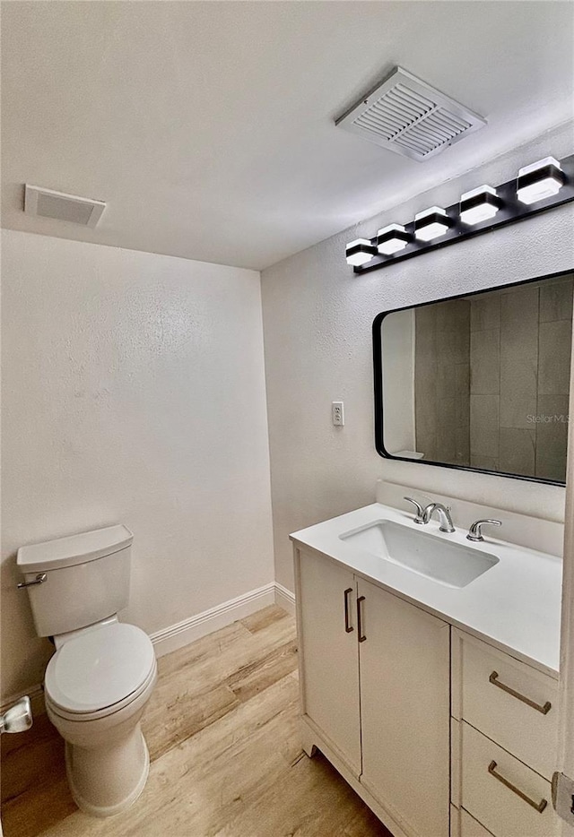 bathroom featuring visible vents, vanity, toilet, and wood finished floors