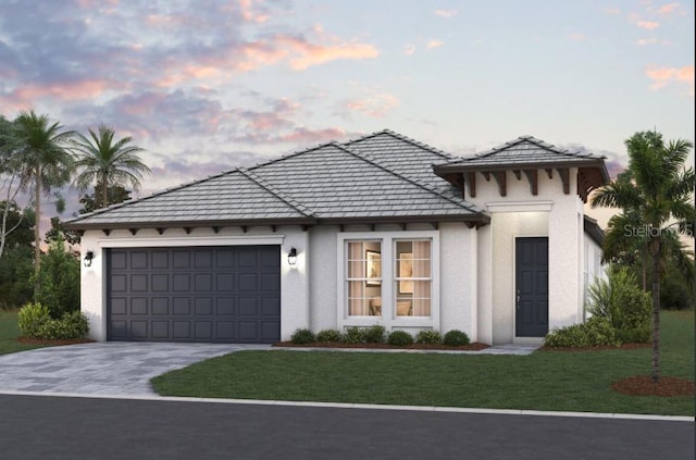 view of front of house with driveway, a front lawn, an attached garage, and stucco siding