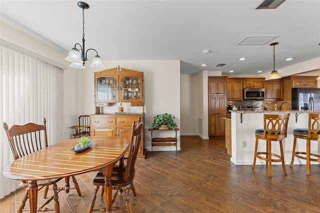 dining area featuring dark wood finished floors, a notable chandelier, recessed lighting, visible vents, and baseboards