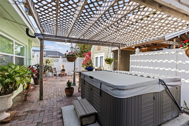 view of patio / terrace with fence and a hot tub