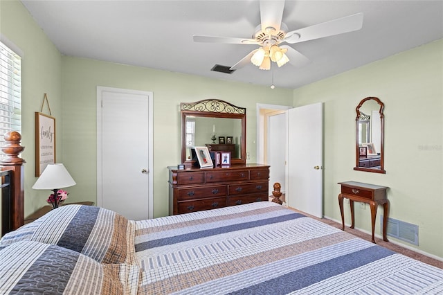 carpeted bedroom with a ceiling fan, visible vents, and baseboards