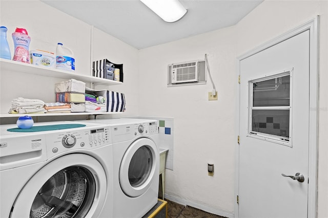 washroom with laundry area, washing machine and dryer, and a wall mounted air conditioner