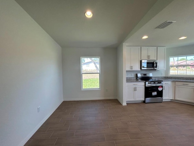 141 W 6th St, Frostproof, FL 33843 - kitchen with appliances with stainless steel finishes, baseboards, recessed lighting, white cabinets, and wood finish floors