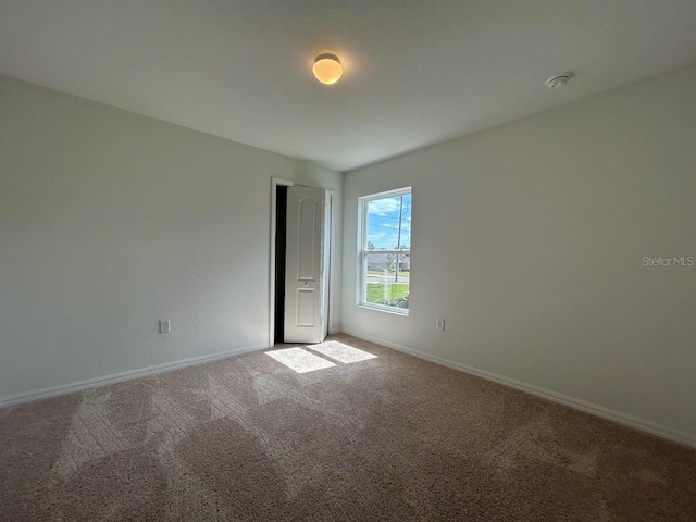141 W 6th St, Frostproof, FL 33843 - carpeted empty room with baseboards and a smoke detector