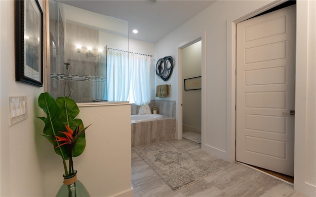 bathroom with recessed lighting, a garden tub, baseboards, and a walk in shower