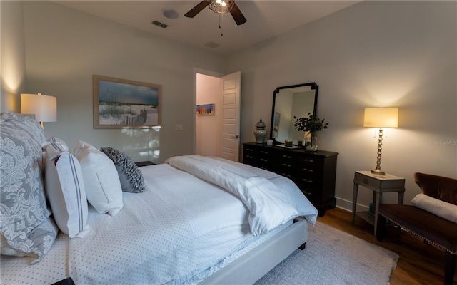 bedroom featuring wood finished floors, visible vents, ceiling fan, and baseboards