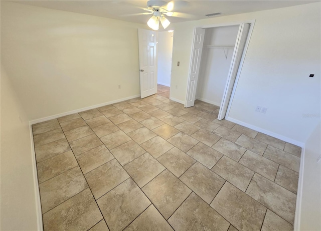 unfurnished bedroom with a closet, light tile patterned floors, ceiling fan, baseboards, and visible vents