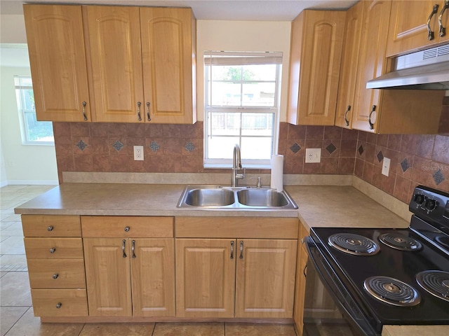 kitchen featuring under cabinet range hood, light countertops, backsplash, a sink, and black electric range