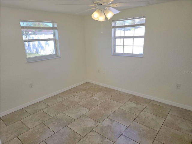 spare room featuring plenty of natural light, baseboards, and ceiling fan