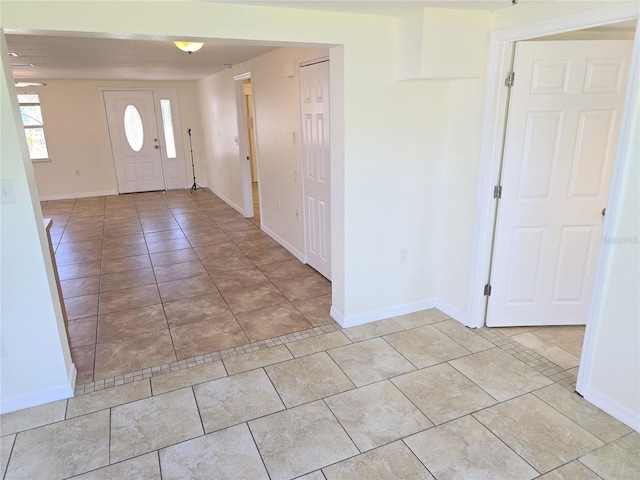 entryway with baseboards and light tile patterned floors