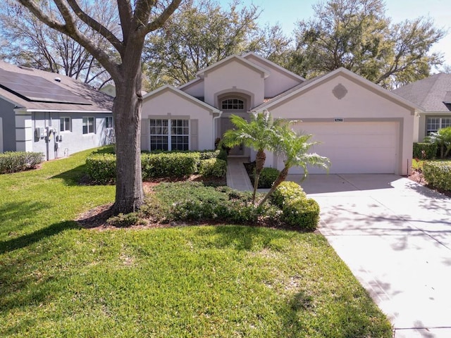 mediterranean / spanish-style house featuring a garage, driveway, a front yard, and stucco siding