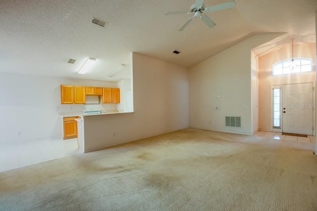 unfurnished living room with a ceiling fan, lofted ceiling, light carpet, and visible vents