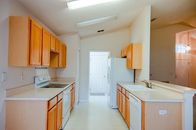 kitchen featuring white appliances, a peninsula, vaulted ceiling, light countertops, and a sink