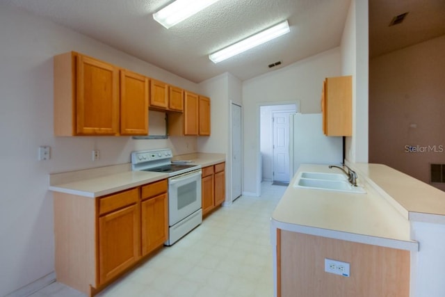 kitchen with lofted ceiling, white appliances, a sink, light countertops, and light floors