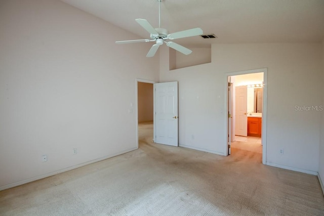 unfurnished bedroom featuring light colored carpet, visible vents, connected bathroom, high vaulted ceiling, and baseboards