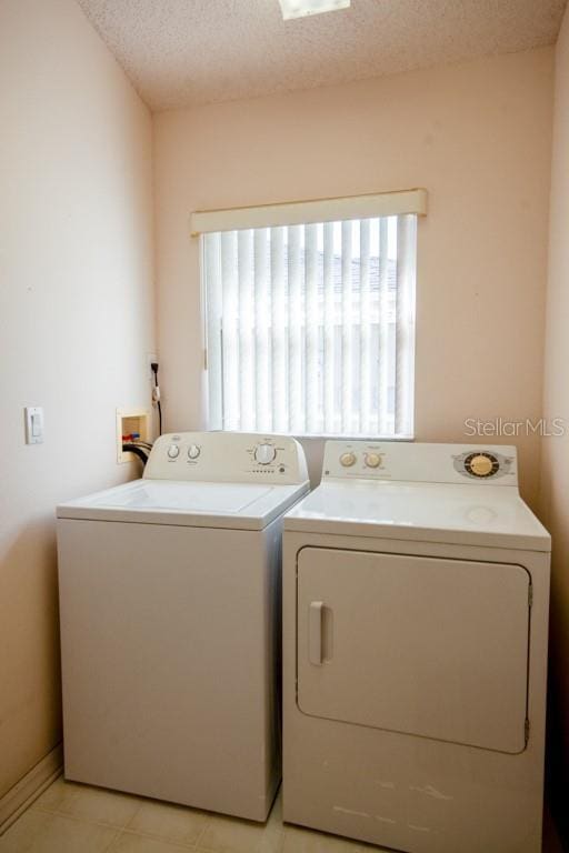 laundry area featuring a textured ceiling, laundry area, and washing machine and dryer