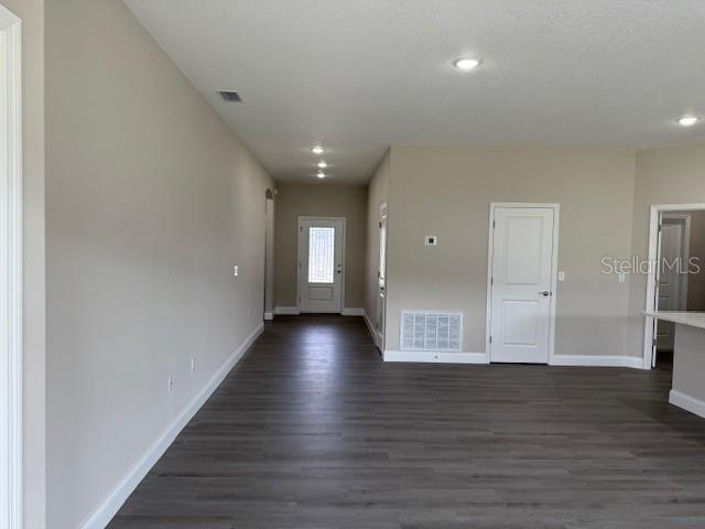 entryway featuring dark wood-style floors, visible vents, and baseboards