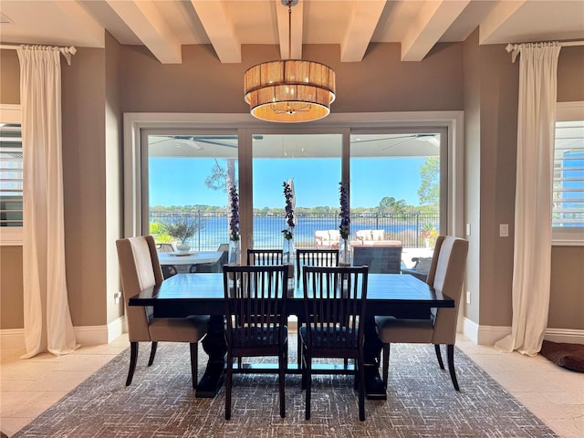 dining area featuring tile patterned floors, baseboards, beam ceiling, and a water view