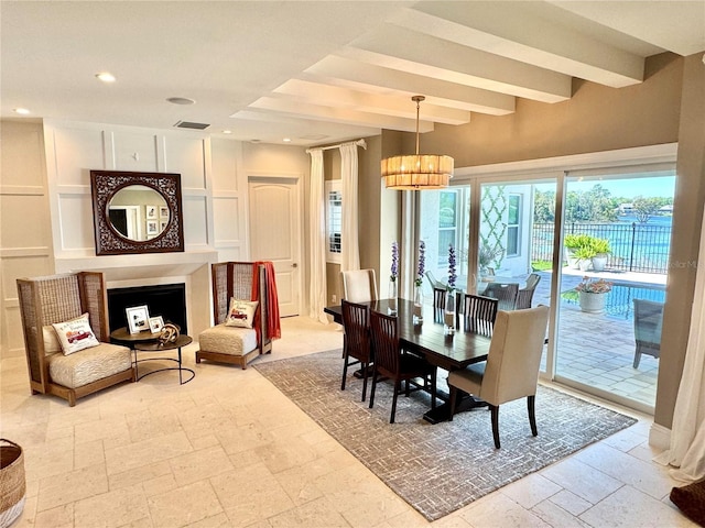 dining room featuring beamed ceiling, recessed lighting, a chandelier, and stone tile flooring