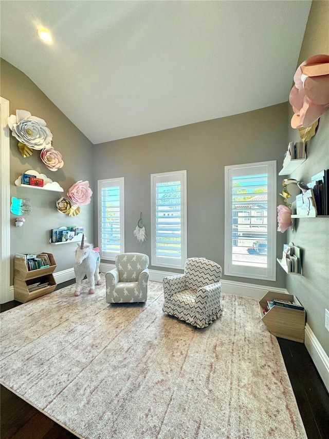 sitting room featuring baseboards, lofted ceiling, and wood finished floors