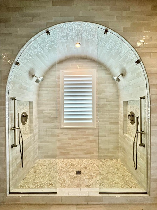 full bath featuring lofted ceiling and a tile shower