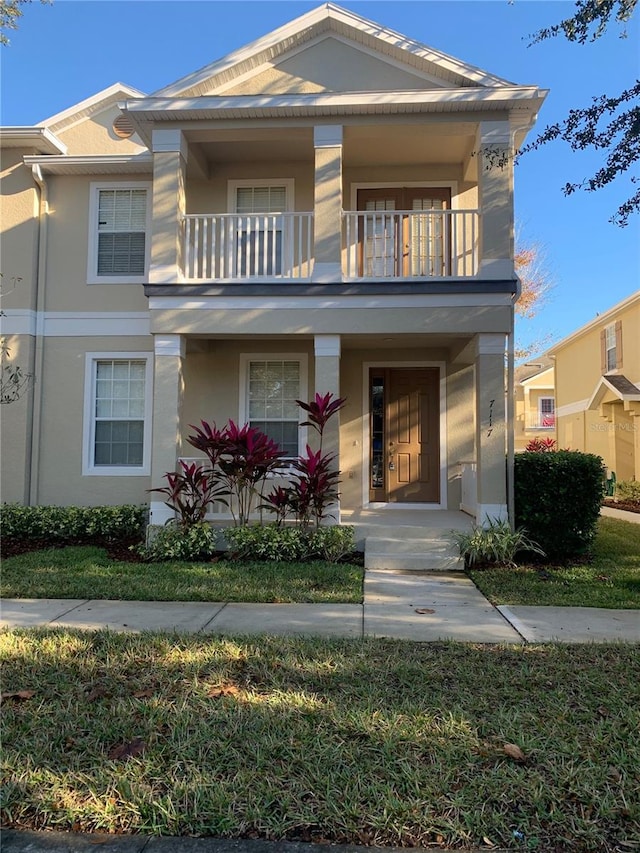 view of front of house featuring a balcony and stucco siding