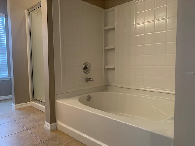 bathroom with a shower with door, baseboards, a tub to relax in, a wealth of natural light, and tile patterned floors