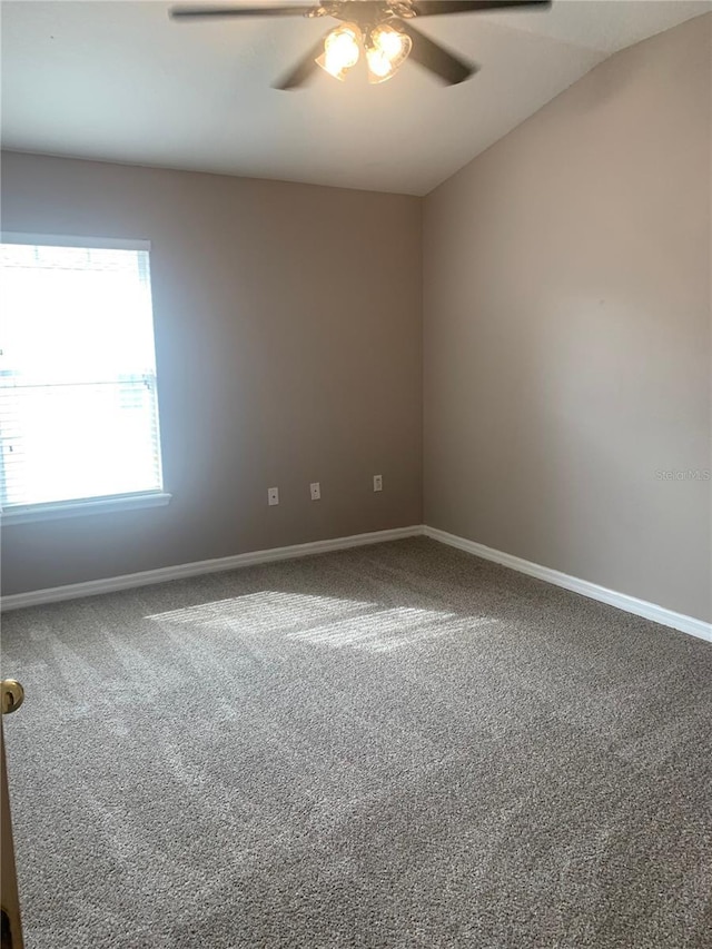 carpeted spare room with baseboards and ceiling fan