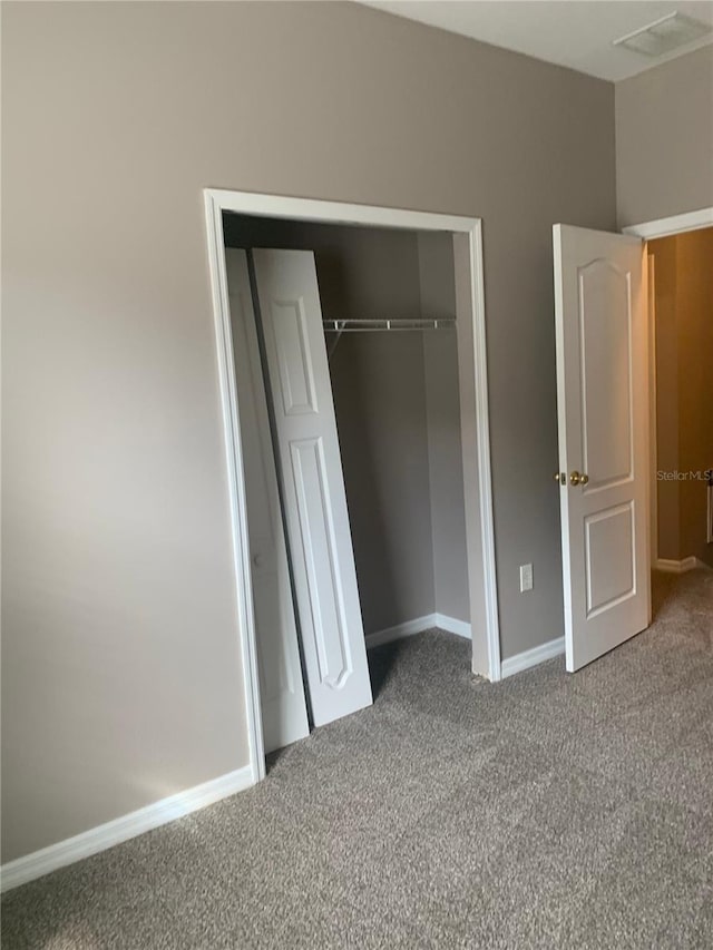 unfurnished bedroom featuring a closet, carpet flooring, and baseboards