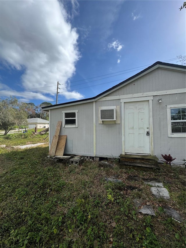 back of property featuring an AC wall unit and entry steps