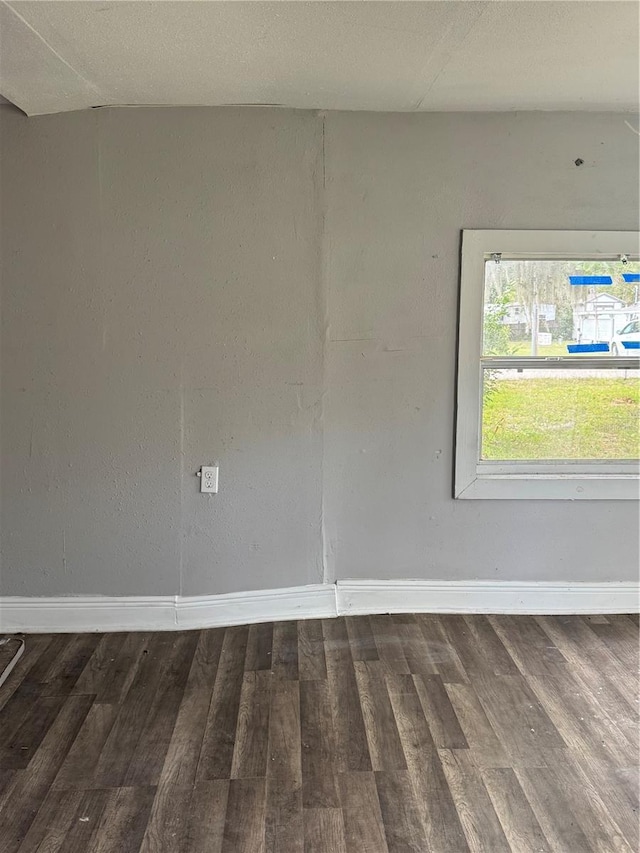 empty room featuring wood finished floors and baseboards