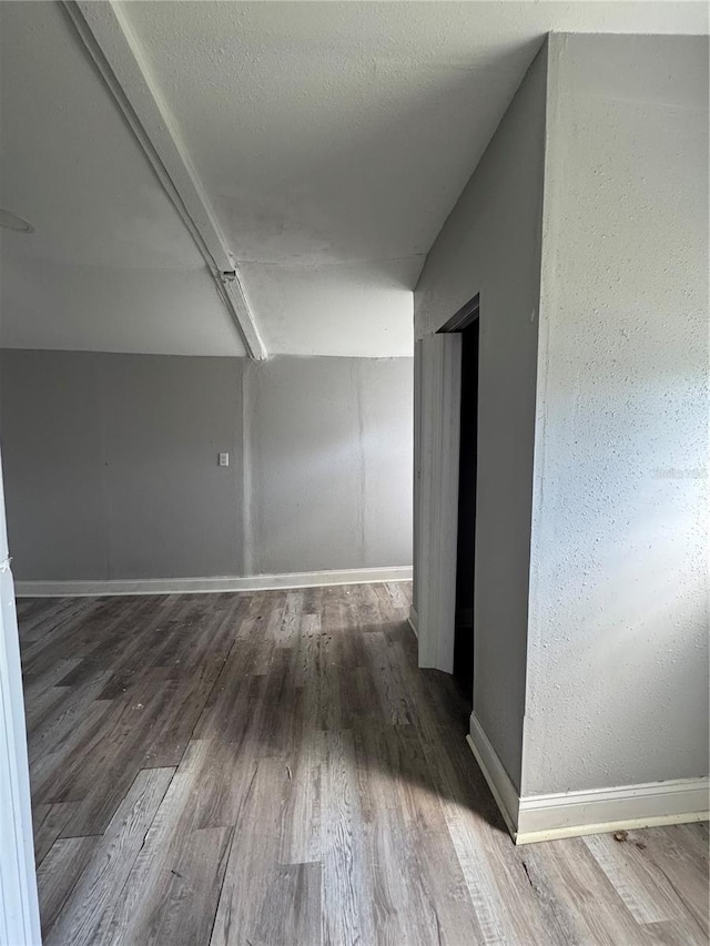 corridor with wood finished floors and baseboards