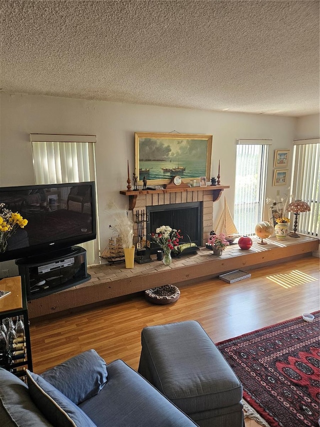 8744 54th Ave W Unit 8744, Bradenton, FL 34210 - living room featuring wood finished floors, a fireplace, and a textured ceiling