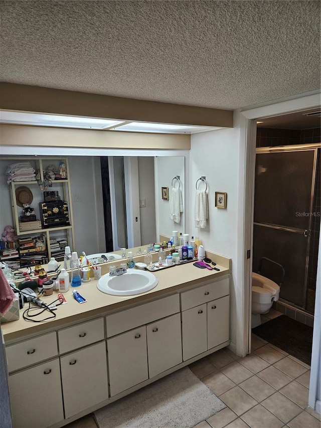 8744 54th Ave W Unit 8744, Bradenton, FL 34210 - full bathroom featuring a stall shower, vanity, a textured ceiling, tile patterned floors, and toilet