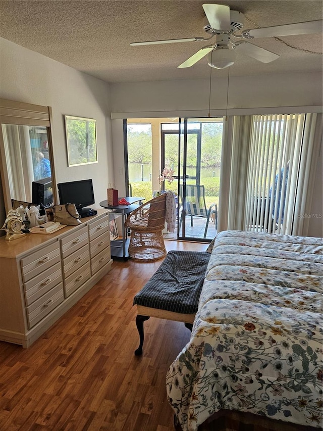 8744 54th Ave W Unit 8744, Bradenton, FL 34210 - bedroom with access to exterior, wood finished floors, a ceiling fan, and a textured ceiling