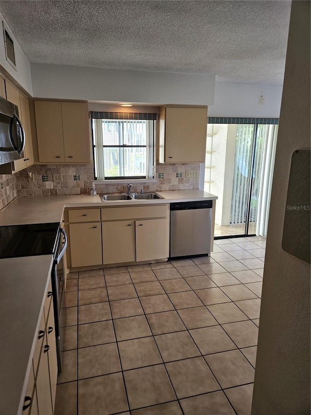 8744 54th Ave W Unit 8744, Bradenton, FL 34210 - kitchen featuring stainless steel appliances, a sink, tasteful backsplash, light countertops, and a textured ceiling