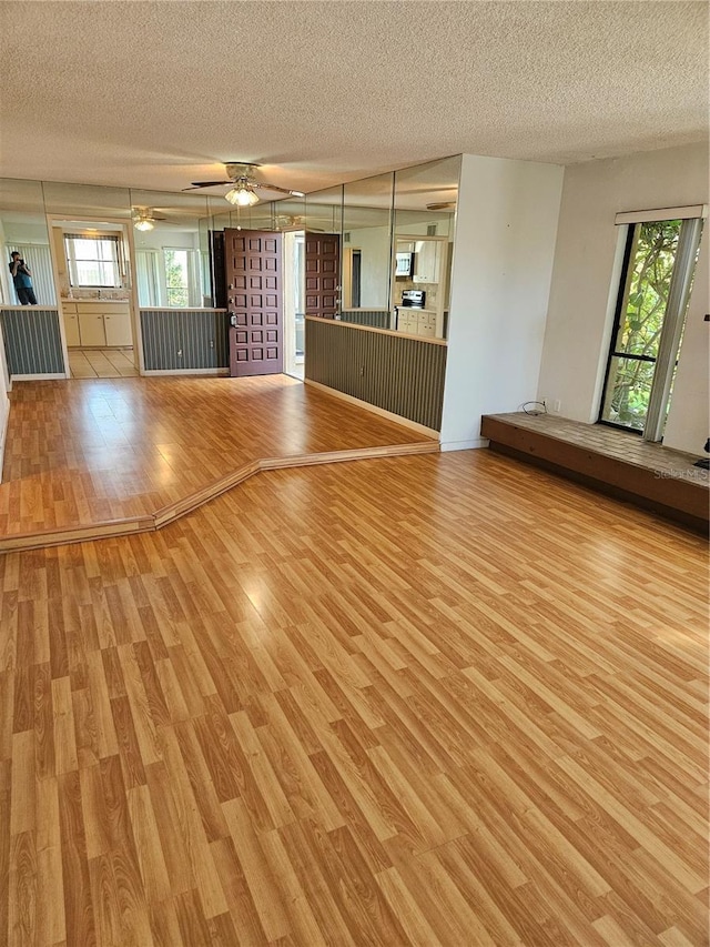 8744 54th Ave W Unit 8744, Bradenton, FL 34210 - unfurnished living room with light wood-style floors, a textured ceiling, and ceiling fan