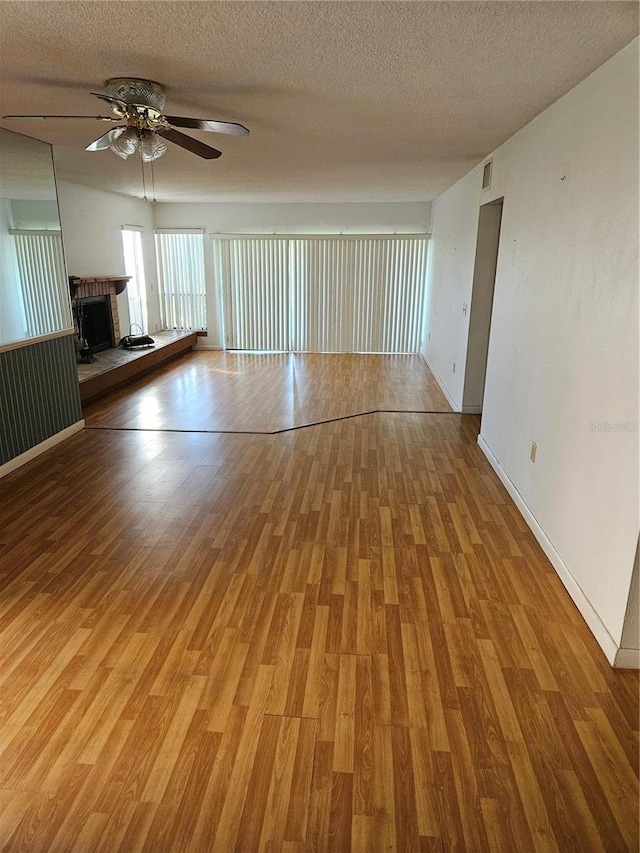 8744 54th Ave W Unit 8744, Bradenton, FL 34210 - unfurnished living room with a ceiling fan, light wood finished floors, a textured ceiling, and baseboards
