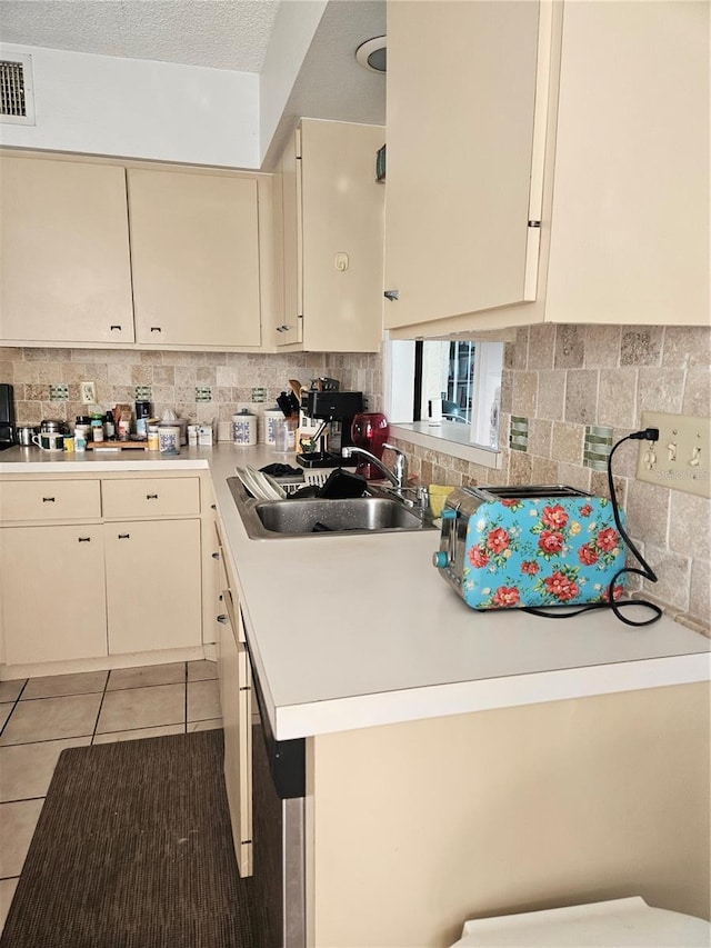 8744 54th Ave W Unit 8744, Bradenton, FL 34210 - kitchen with cream cabinetry, a sink, light countertops, backsplash, and light tile patterned flooring
