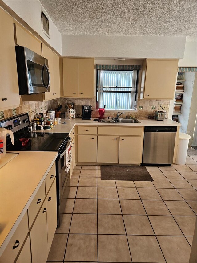 8744 54th Ave W Unit 8744, Bradenton, FL 34210 - kitchen featuring appliances with stainless steel finishes, a sink, cream cabinetry, a textured ceiling, and light countertops