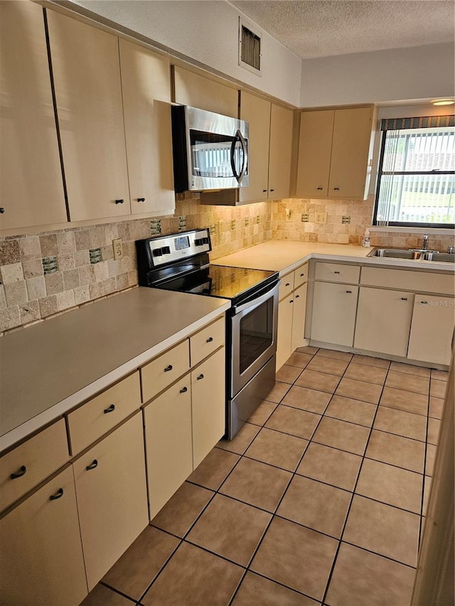 8744 54th Ave W Unit 8744, Bradenton, FL 34210 - kitchen with stainless steel appliances, a sink, decorative backsplash, light countertops, and a textured ceiling