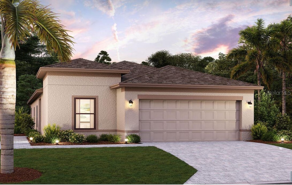 view of front of house with a front yard, roof with shingles, an attached garage, stucco siding, and decorative driveway